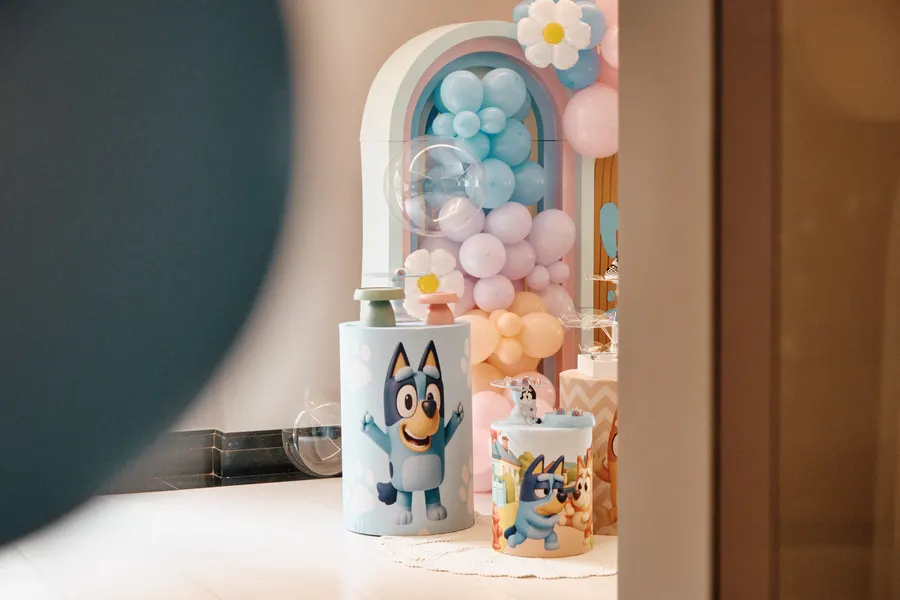 Detalhes da mesa de aniversário com doces, balões coloridos e decoração infantil.